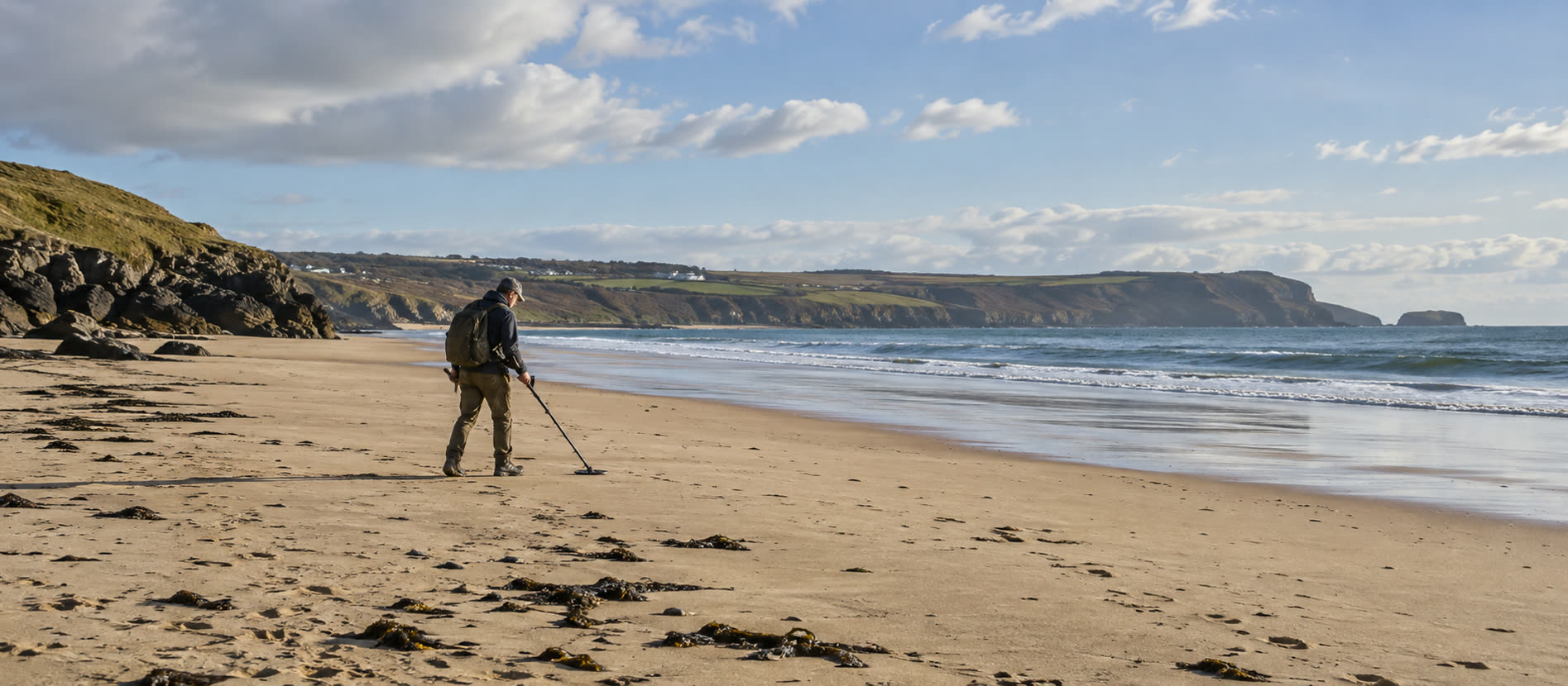 Detectorist sweeping the upper sand of a broad British beach